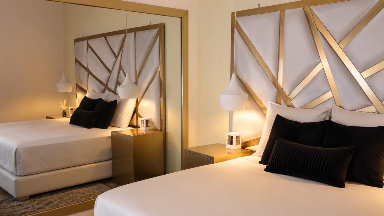 Habitación con cabecero blanco y dorado
